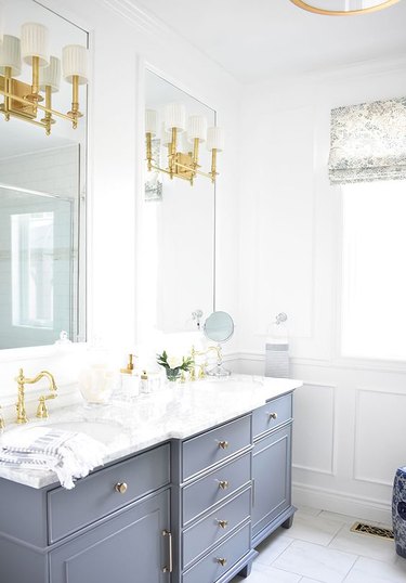 brass vanity light attached to mirror in traditional bathroom