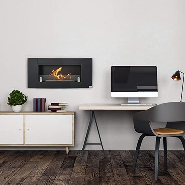 A black wall-mounted ethanol fireplace in a home office