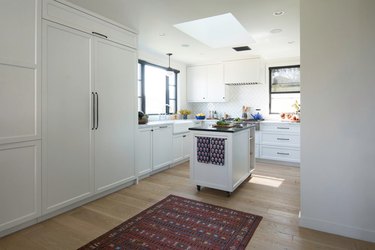 white kitchen with rug that takes up negative space