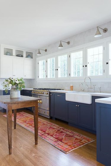 navy and white kitchen with antique work table and pink runner