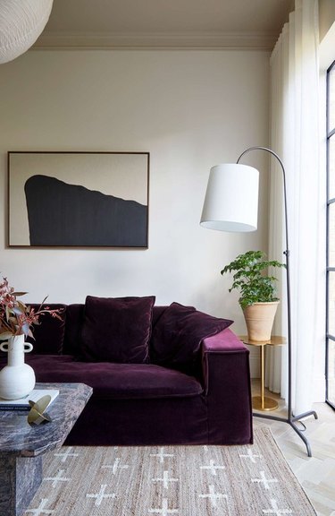 sitting room with taupe rug and magenta sofa