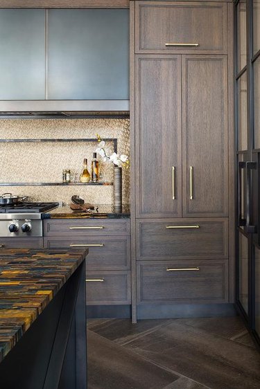 kitchen with brown cabinets and gold backsplash