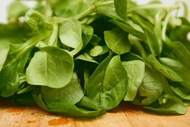 Baby spinach on a wooden cutting board