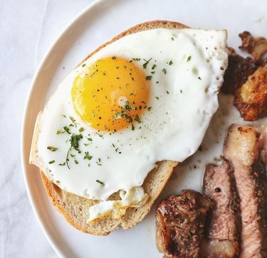 sunny side up egg on toast next to meat