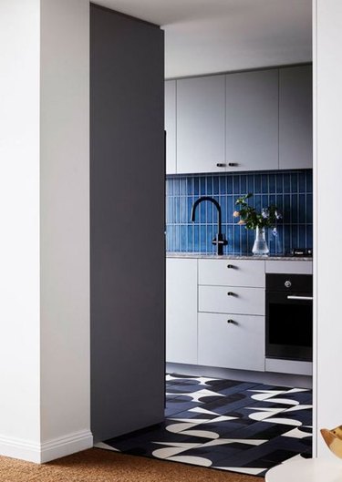 gray kitchen cabinets with navy blue backsplash