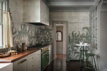 gray kitchen cabinets with green mural on wall