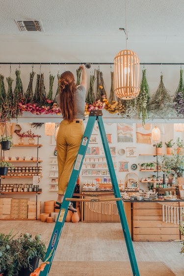 person hanging flowers in a shop