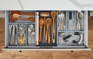 An organized kitchen drawer filled with utensils, serving ware and kitchen tools.