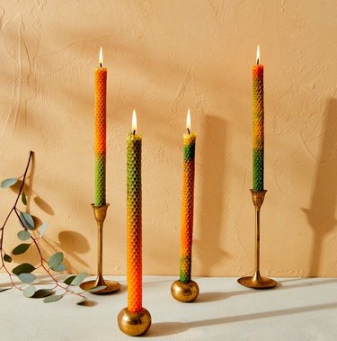 four green and orange candlesticks on gold candle holders