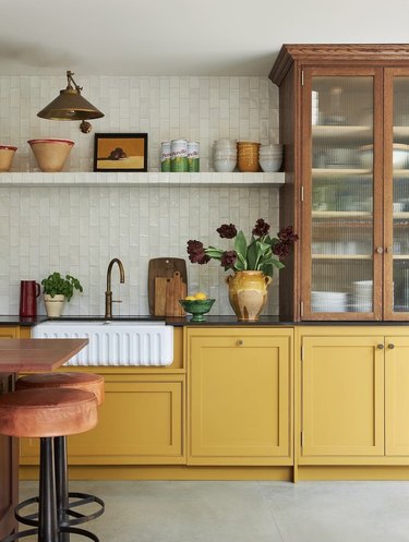 kitchen with gray tile walls and yellow cabinets