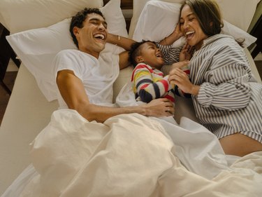 happy family laughing in bed