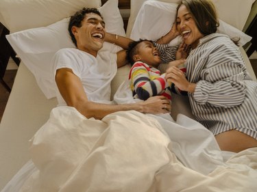 family laughing in bed