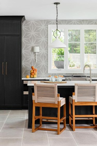 kitchen with black cabinets and gray patterned wallpaper