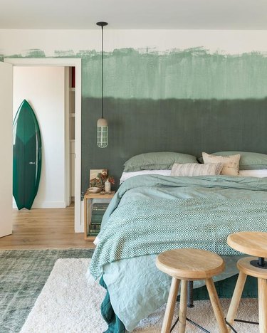 bedroom with seafoam green duvet and accents in sage, olive, and emerald green
