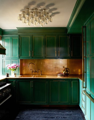 green kitchen with copper backsplash