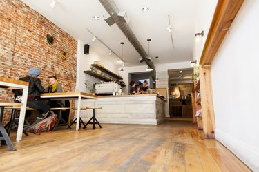Interior of a cafe with wood floors and a brick wall