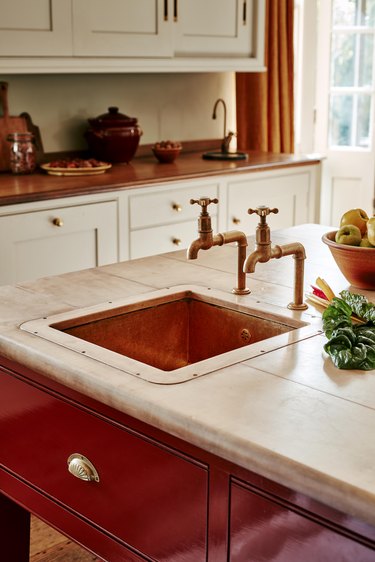 kitchen with copper sink and faucet on red island