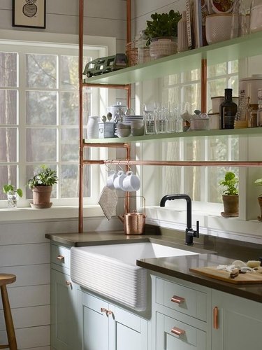kitchen with copper pipe shelf, light blue cabinets, and light green shelves