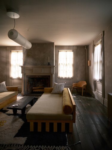 living room with earthy color palette features a pair of daybeds in front of fireplace