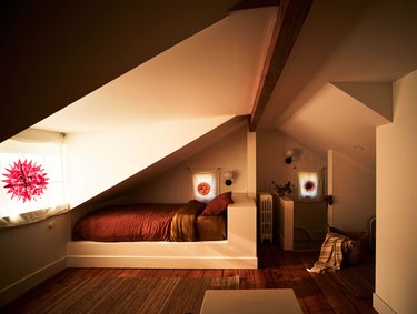 alcove beds in guest room with slanted ceilings and decorative shades at the windows