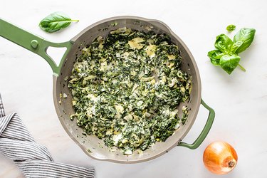 Mixing cream cheese with spinach and artichokes