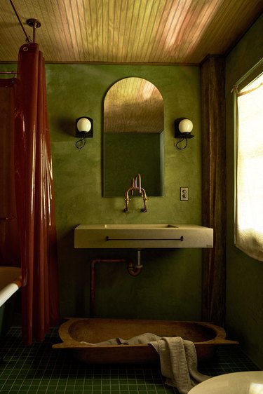 downstairs bathroom with green concrete walls and mosaic tile flooring