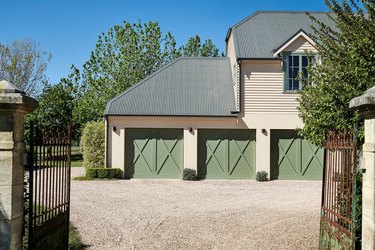 taupe garage with green roof and doors