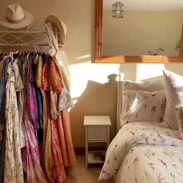bedroom with floral dresses on clothing rack