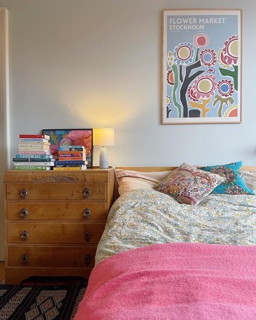 bedroom with flower-print poster and vintage dresser