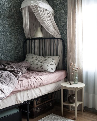 bedroom with black metal bedframe and white canopy