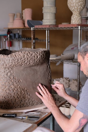 person creating ceramic piece in a studio