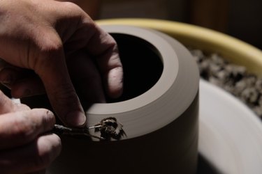 close-up of person's hand on ceramic wheel