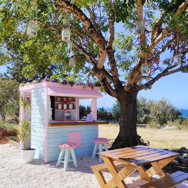 photo of outdoor space with table and playhouse coffee shop in pastel colors