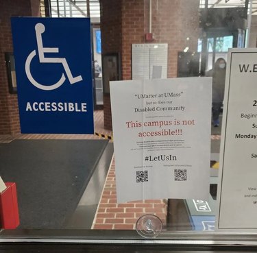 A "UMatter at UMass" sign reading, "This campus is not accessible," next to an Accessible sign featuring a person in a wheelchair