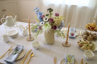 Tea party tablescape with flower centerpiece, tiered serving tray and teapot