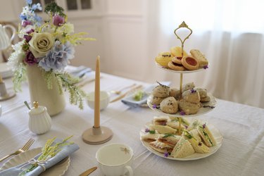Three-tiered serving tray with tea sandwiches, scones, and pastries