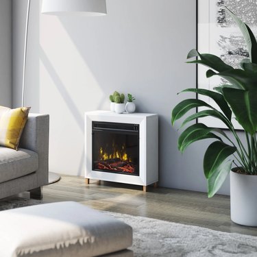 A white portable electric fireplace in a gray living room