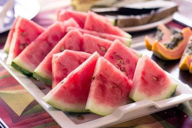 slices of watermelon on plate near other fruit