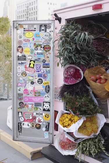 pink truck with door open and flowers and greenery inside