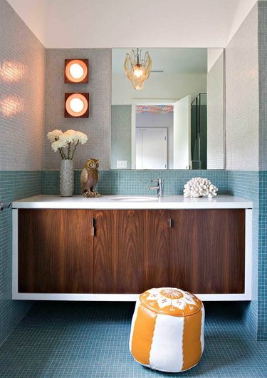 Bathroom with walnut vanity and aqua tile backsplash.