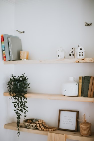 wood floating shelves with decorative items against white wall