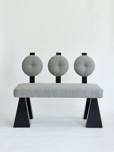 gray bench with round back and black legs