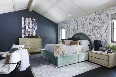 headboard in sage green color goes with navy blue accent wall in bedroom