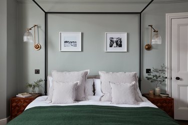sage green walls and hunter green blanket in bedroom