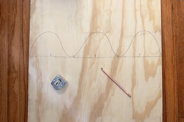 Wavy shape drawn on plywood board with three wave crests