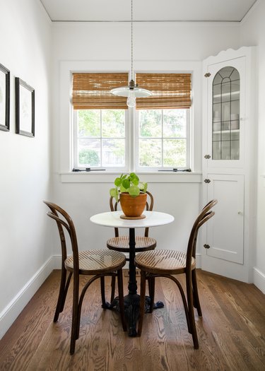Small dining corner with a built-in cabinet, coffee table with chairs, and window with natural shade.