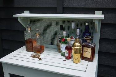 Various alcohol bottles set up on potting bench for cocktail station