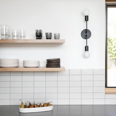 white kitchen with midcentury black wall sconce