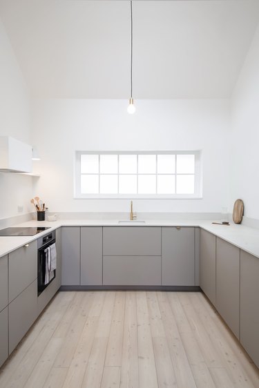 simple modern kitchen with gray cabinets and window