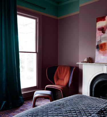 Bedroom with purple walls, teal curtains.